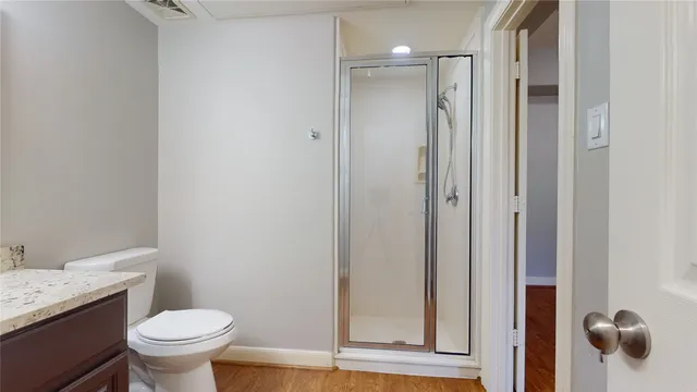 a bathroom with a granite countertop toilet a sink and a mirror