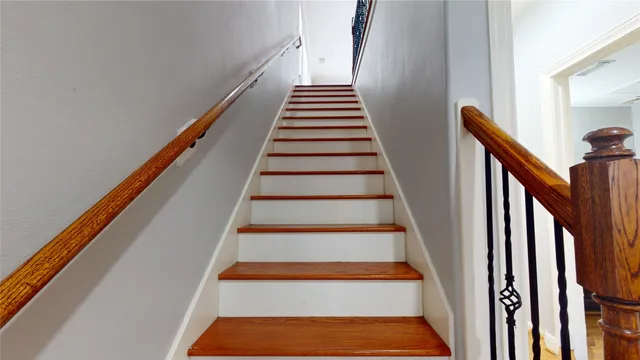 a view of staircase with wooden floor and white walls
