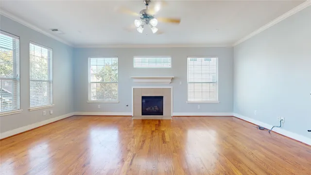 a view of empty room with wooden floor fireplace and windows