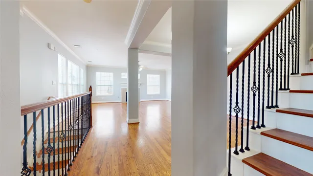 a view of a hallway with wooden floor and windows