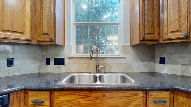 a kitchen with stainless steel appliances granite countertop a sink and a window