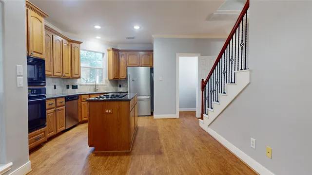a kitchen with sink a refrigerator and wooden floor