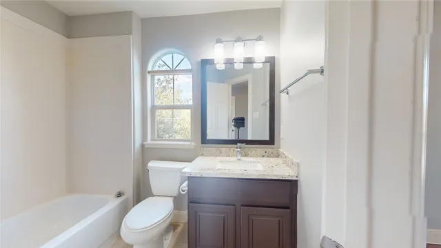 a bathroom with a granite countertop toilet a sink and a mirror