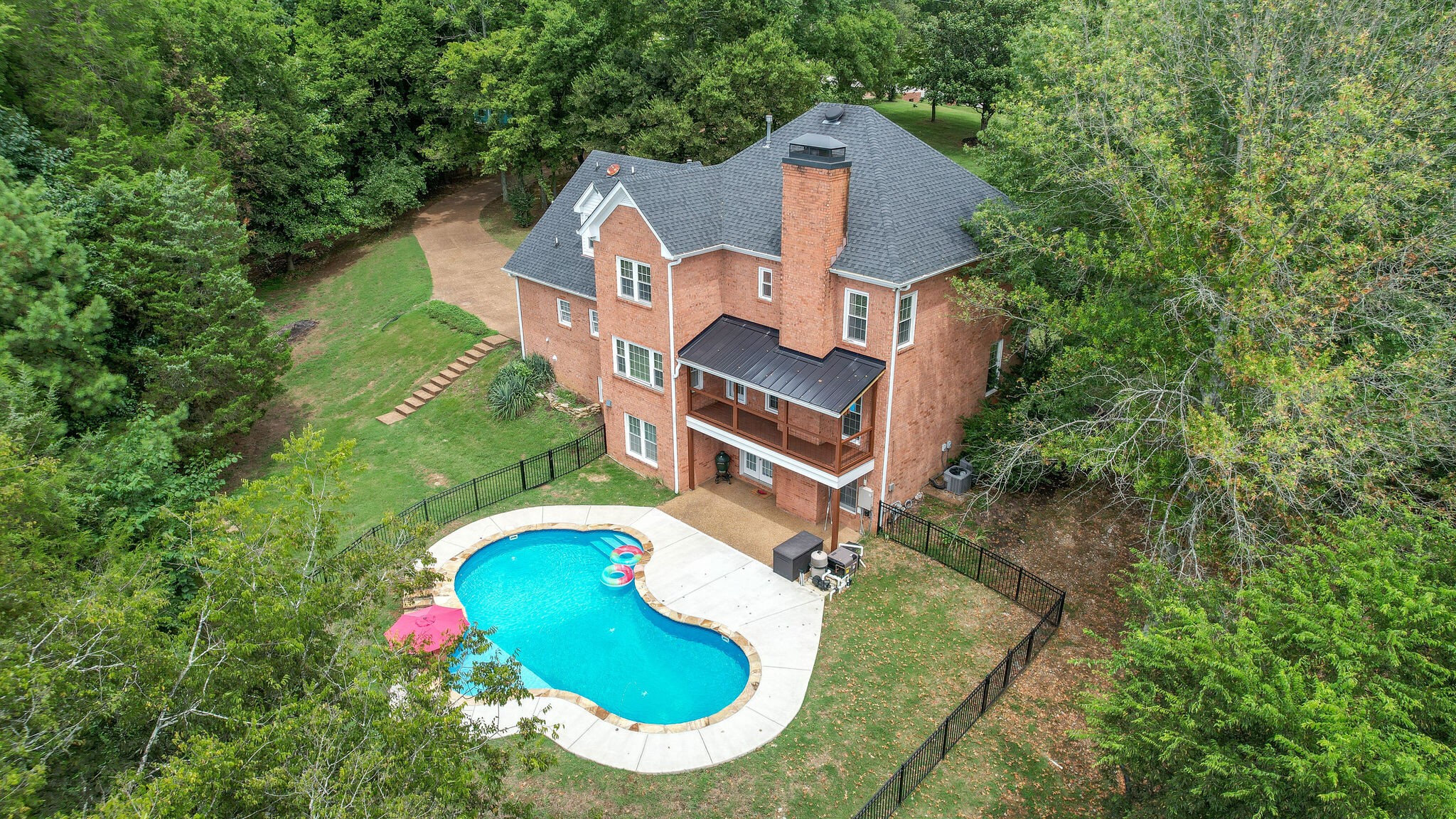 an aerial view of a house with outdoor space and swimming pool