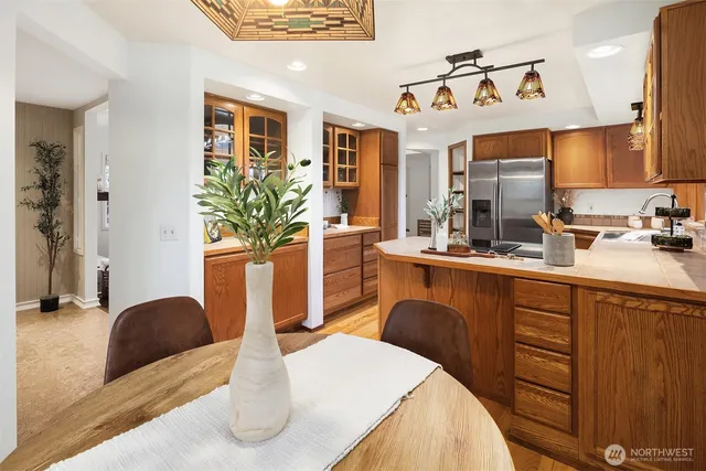 a kitchen with stainless steel appliances kitchen island granite countertop a table chairs in it and wooden floors