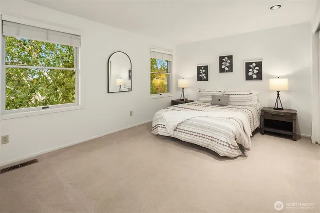 a bedroom with a bed and a large window