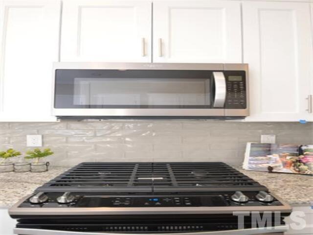 102 Philip's Square Chapel Hill, NC 27516 - Photo 6 of 25 a kitchen with wooden cabinets and a stove top oven