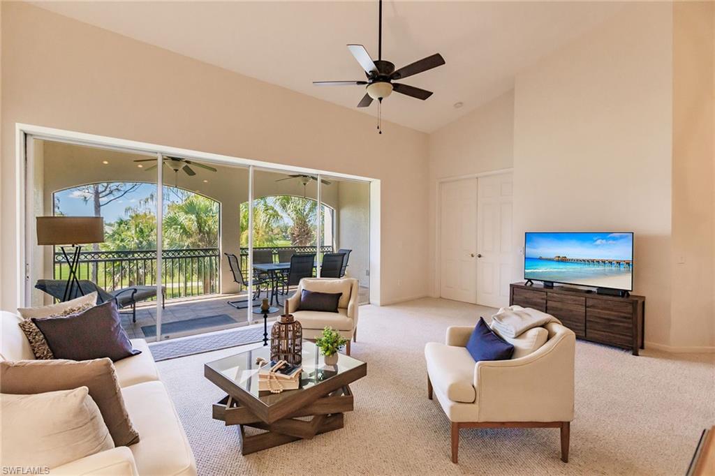 3940 Deer Crossing Court, Unit 4203 Naples, FL 34114 - Photo 14 of 46 a living room with furniture a floor to ceiling window and a flat screen tv