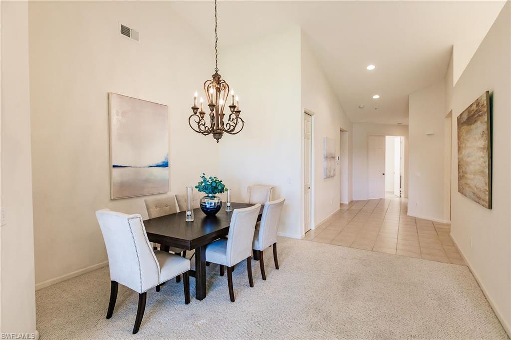 3940 Deer Crossing Court, Unit 4203 Naples, FL 34114 - Photo 16 of 46 a view of a dining room with furniture a chandelier and wooden floor