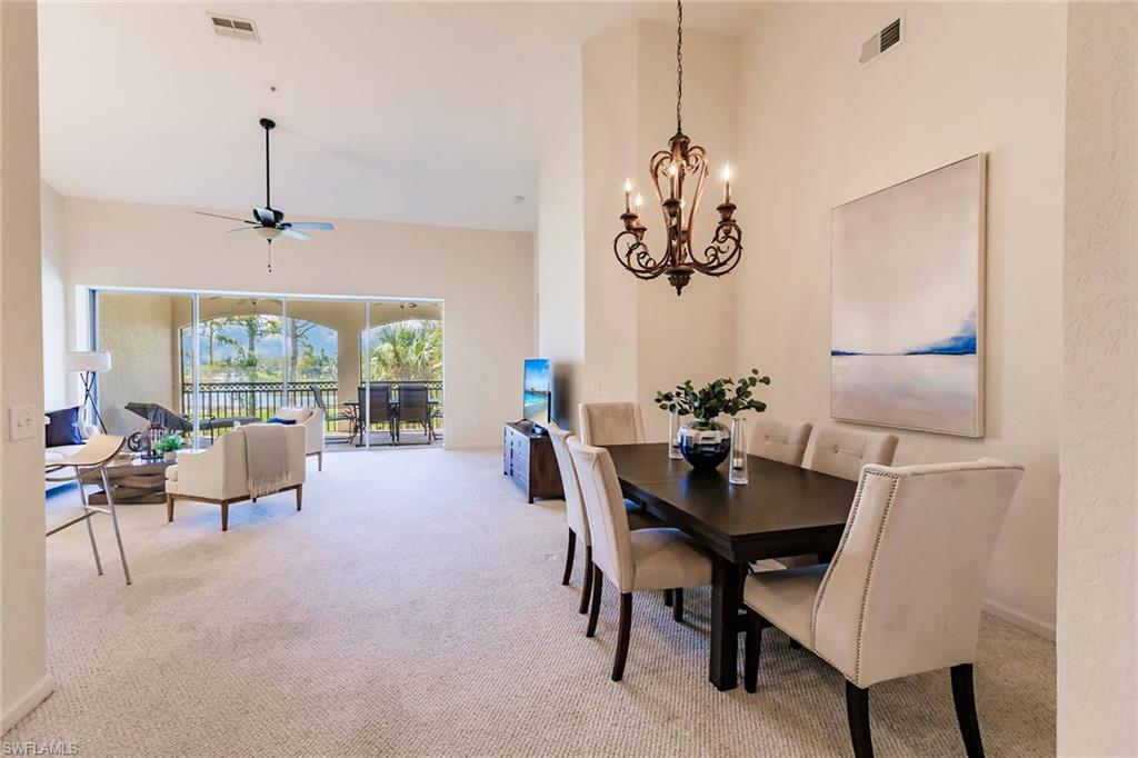 3940 Deer Crossing Court, Unit 4203 Naples, FL 34114 - Photo 19 of 46 a view of a dining room with furniture wooden floor and a chandelier