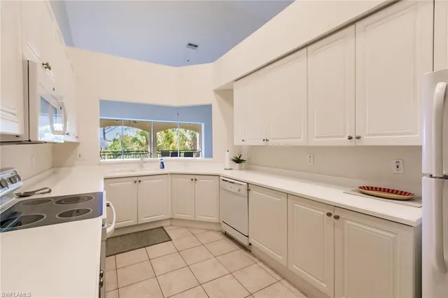 a kitchen with white cabinets and white appliances