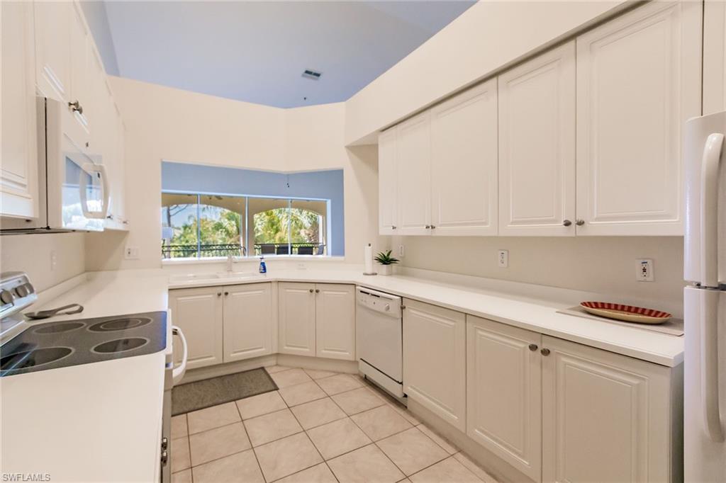 3940 Deer Crossing Court, Unit 4203 Naples, FL 34114 - Photo 21 of 46 a kitchen with a white cabinets and white appliances