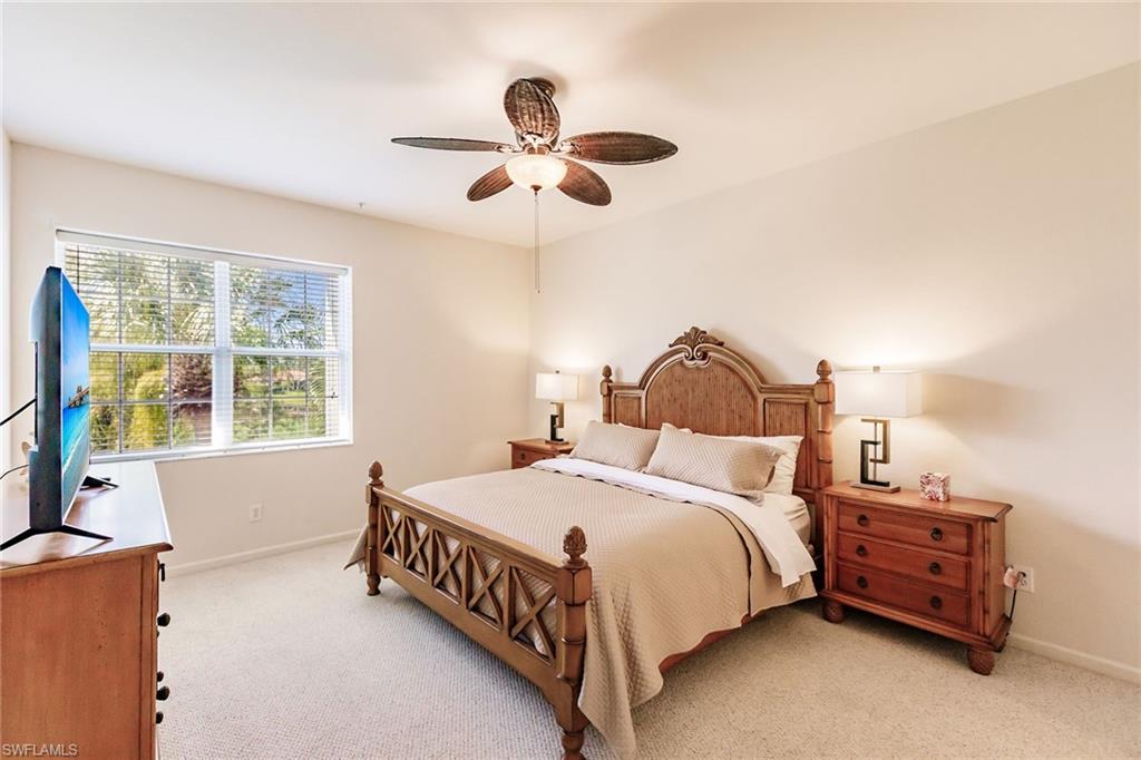 3940 Deer Crossing Court, Unit 4203 Naples, FL 34114 - Photo 28 of 46 a bedroom with a bed and a chandelier