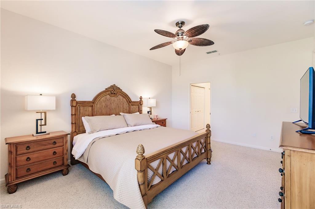 3940 Deer Crossing Court, Unit 4203 Naples, FL 34114 - Photo 30 of 46 a bedroom with a bed a chandelier and a dresser