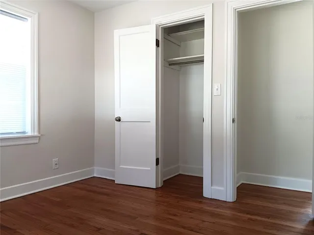 an empty room with wooden floor & closet