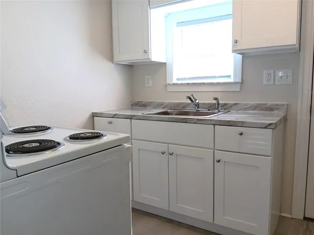 a kitchen with cabinets appliances a sink and a window