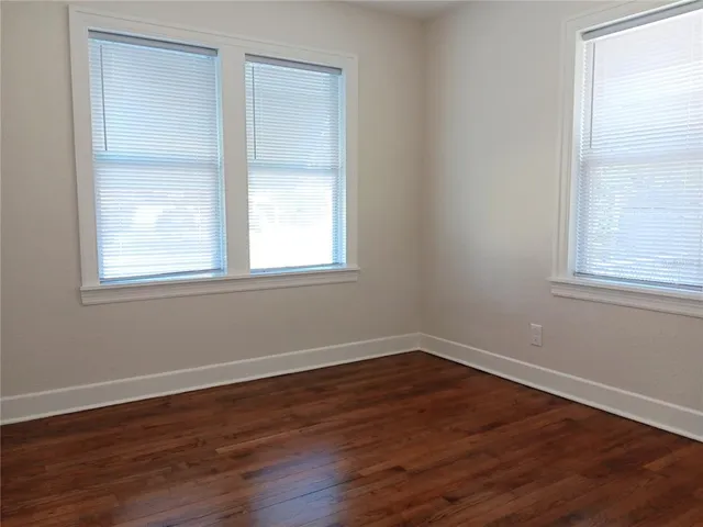a view of a room with wooden floor and windows in it