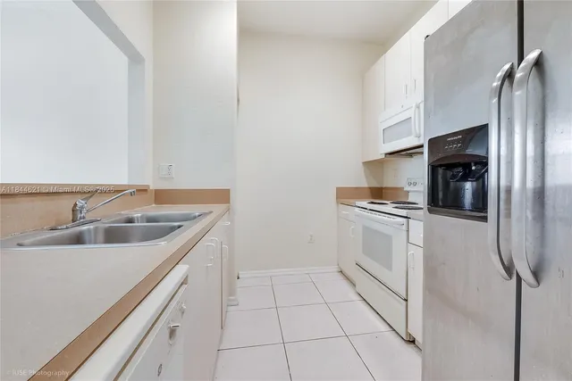 a kitchen with a sink cabinets and stainless steel appliances