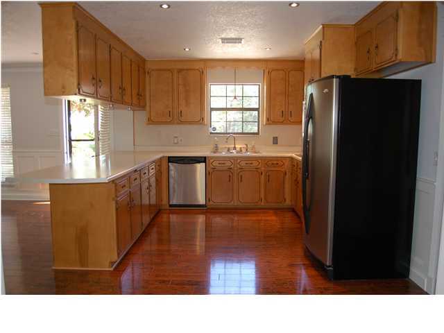 82 East Wild Briar Road Santa Rosa Beach, FL 32459 - Photo 10 of 26 a kitchen with stainless steel appliances kitchen island granite countertop a refrigerator a sink dishwasher and wooden cabinets