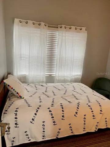 a bedroom with a bed and a window