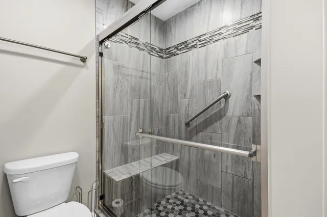 a bathroom with a shower a toilet and sink