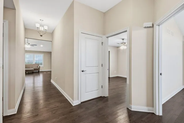 a view of a hallway with wooden floor windows and a livingroom