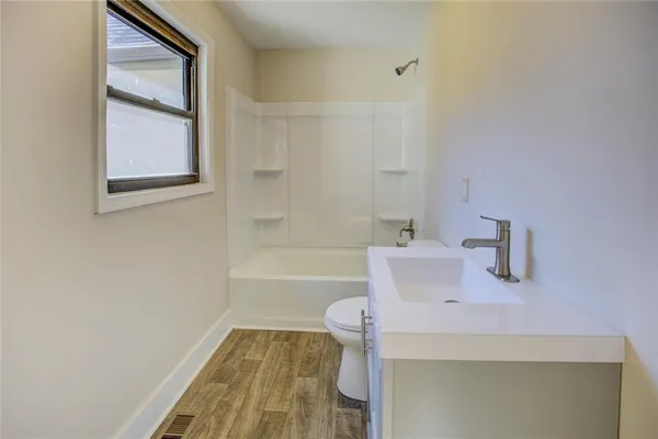 a view of an empty room with a chandelier fan