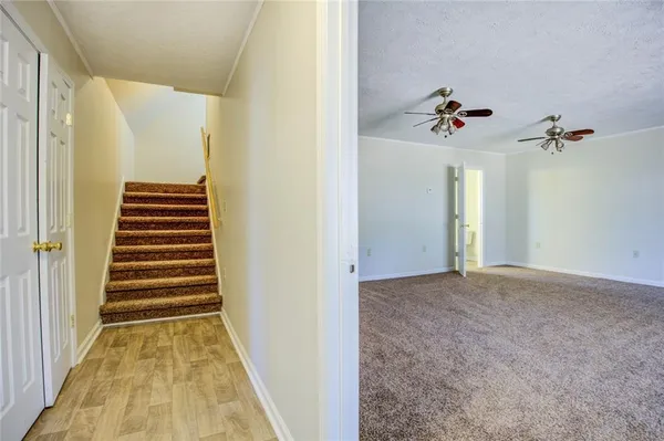 an empty room with windows and fan