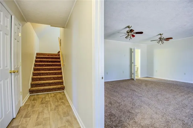 an empty room with windows and fan