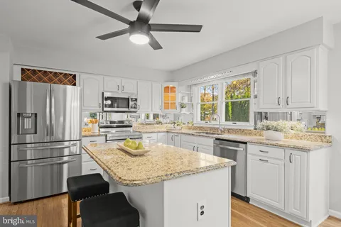 a kitchen with stainless steel appliances granite countertop a sink stove microwave and refrigerator
