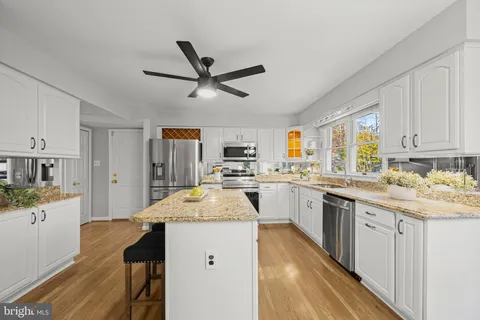 a kitchen with granite countertop a sink appliances cabinets and furniture