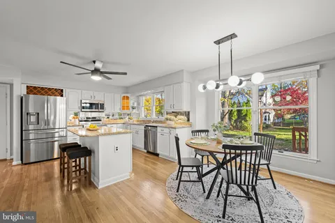 a kitchen with a table chairs appliances and cabinets