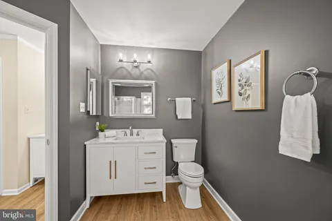 a bathroom with a toilet sink vanity and mirror