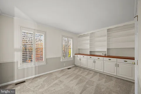 a large white kitchen with granite countertop a large window