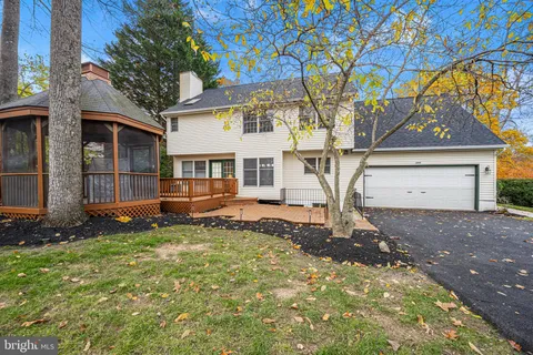 a view of a house with a large tree and a yard