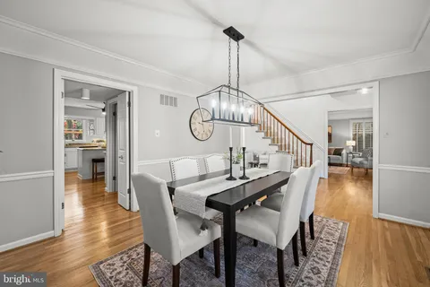 a view of a dining room and livingroom with furniture wooden floor a chandelier