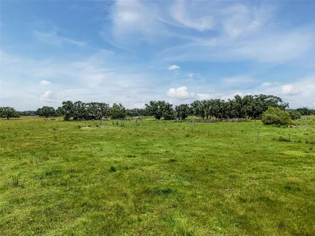 a view of a green field with wooden fence