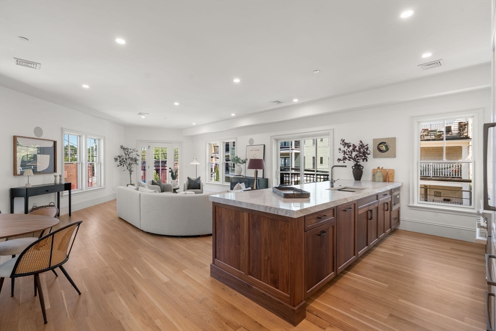 69 Williams Street, Unit 202 Boston, MA 02130 - Photo 8 of 22 a large kitchen with stainless steel appliances granite countertop a large center island and a wooden floors