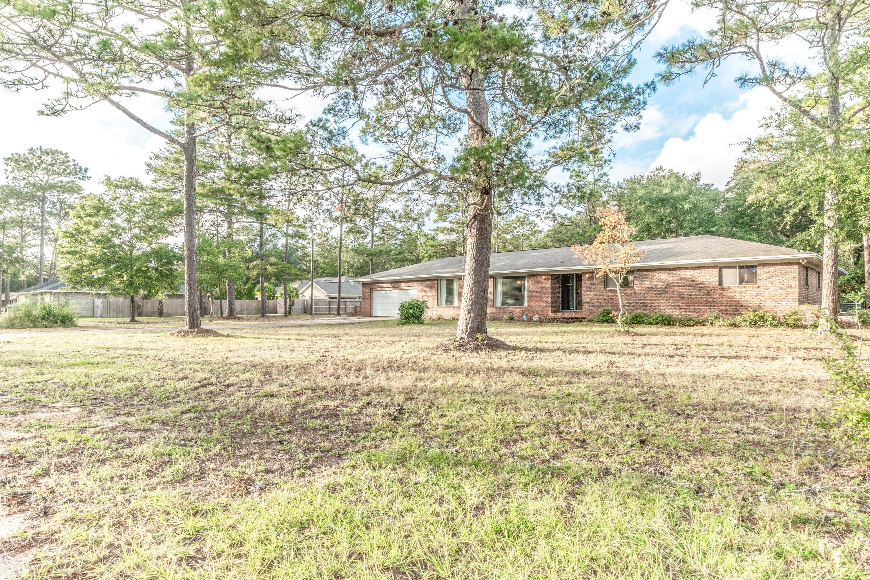 837 Cardinal Street Fort Walton Beach, FL 32547 - Photo 2 of 24 a front view of a house with a garden and trees