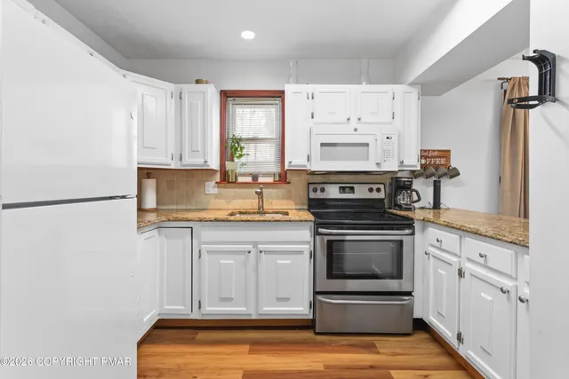 a kitchen with stainless steel appliances granite countertop a stove and a refrigerator