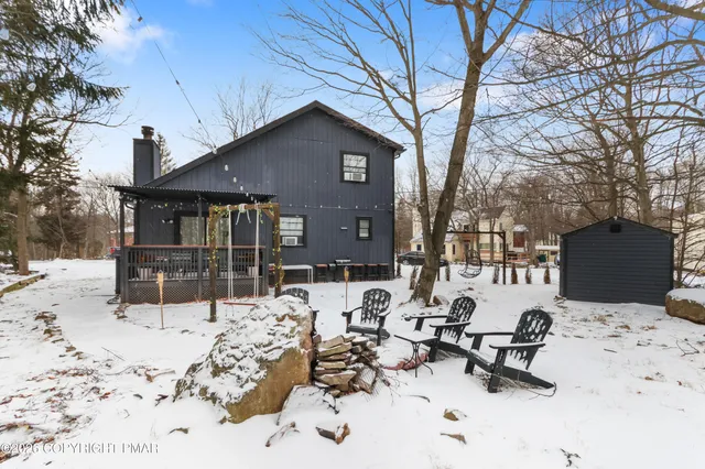 a view of a backyard of snow with a bench