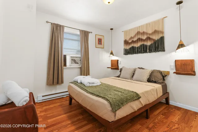 a bedroom with a bed and wooden floor