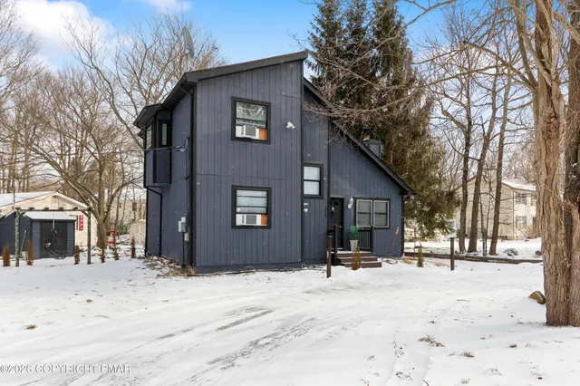 a front view of a house with a yard covered in snow