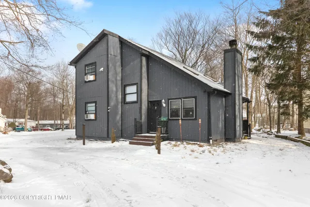 a view of a house with snow on the road