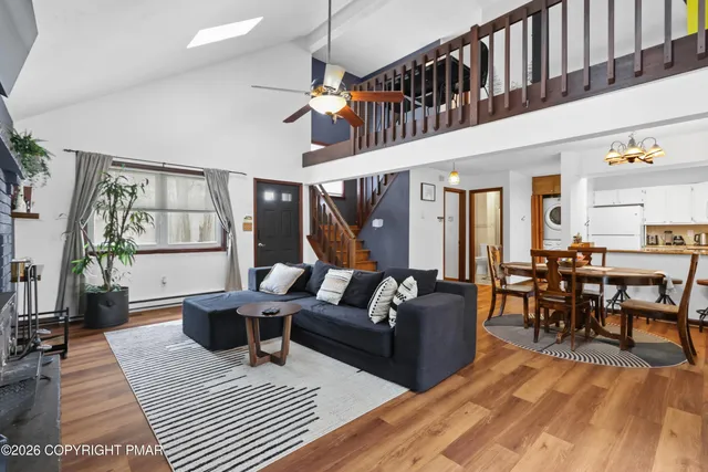 a living room with furniture a flat screen tv and a floor to ceiling window