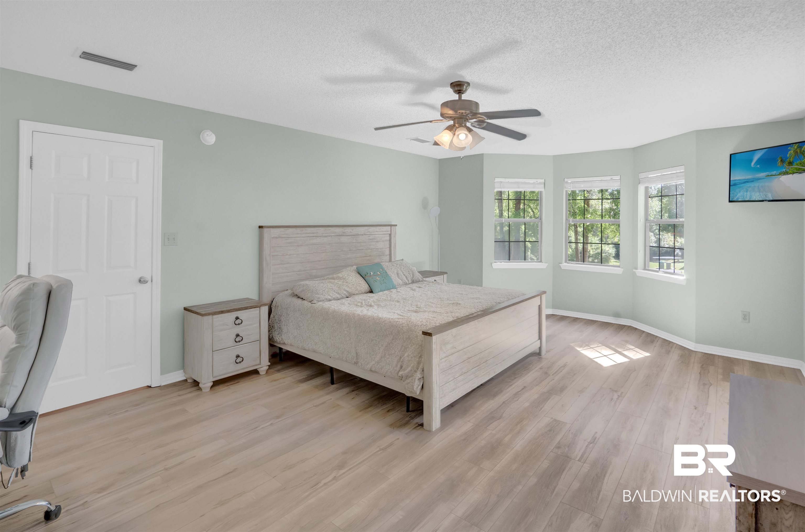 30871 Stanton Road Spanish Fort, AL 36527 - Photo 22 of 35 Bedroom with a textured ceiling, ceiling fan, and light wood-type flooring