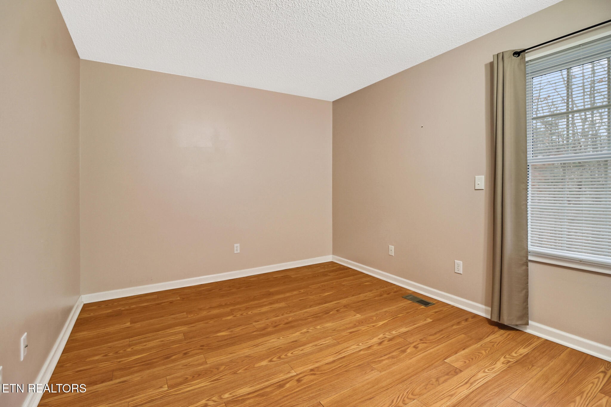 121 St George Drive Crossville, TN 38558 - Photo 30 of 37 an empty room with wooden floor and windows