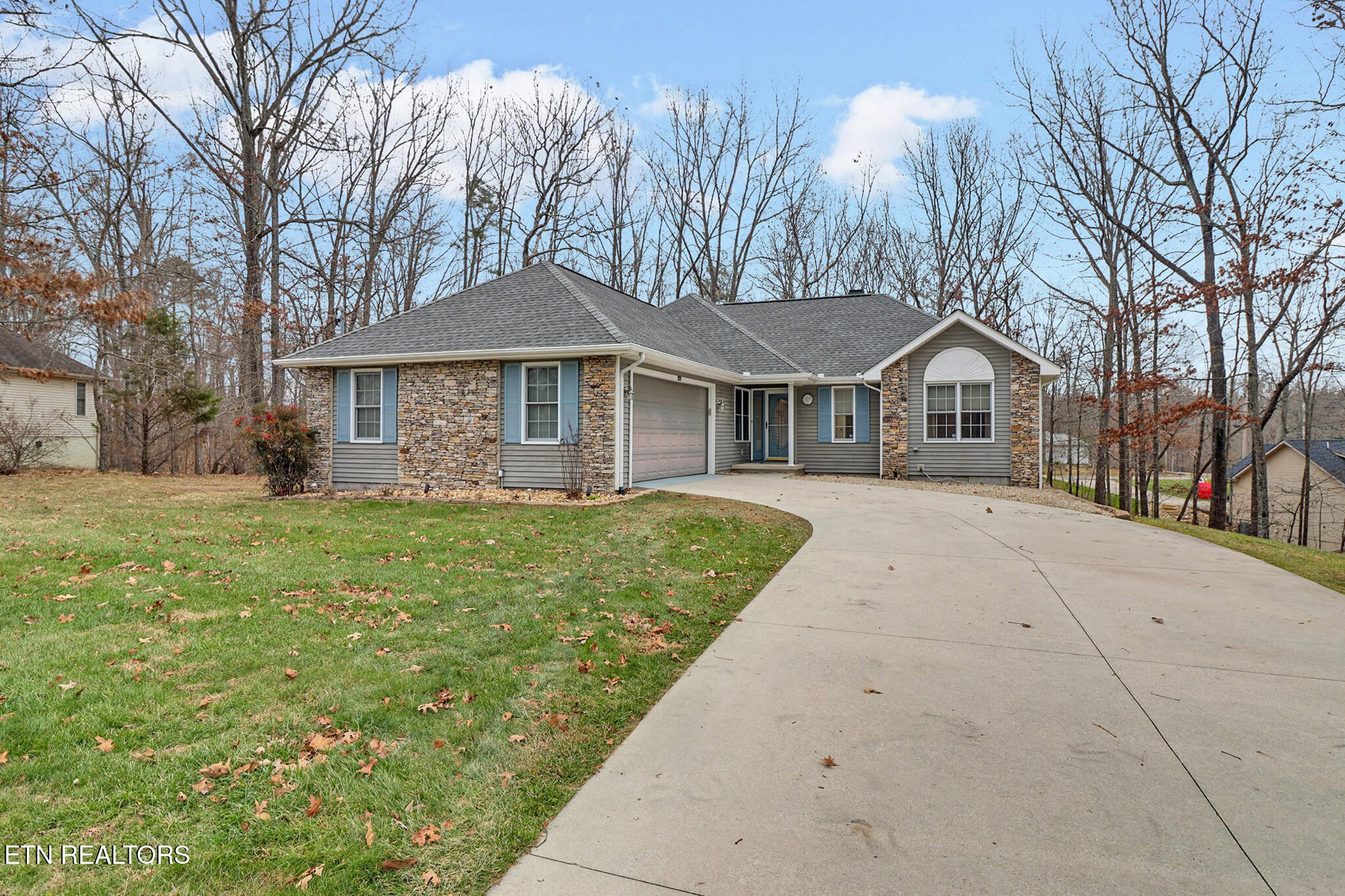 121 St George Drive Crossville, TN 38558 - Photo 3 of 37 a front view of a house with a garden and trees
