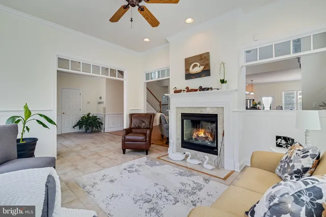 a living room with furniture a fireplace and a chandelier