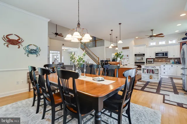 a view of a dining room and livingroom furniture wooden floor a rug a potted plant and a chandelier